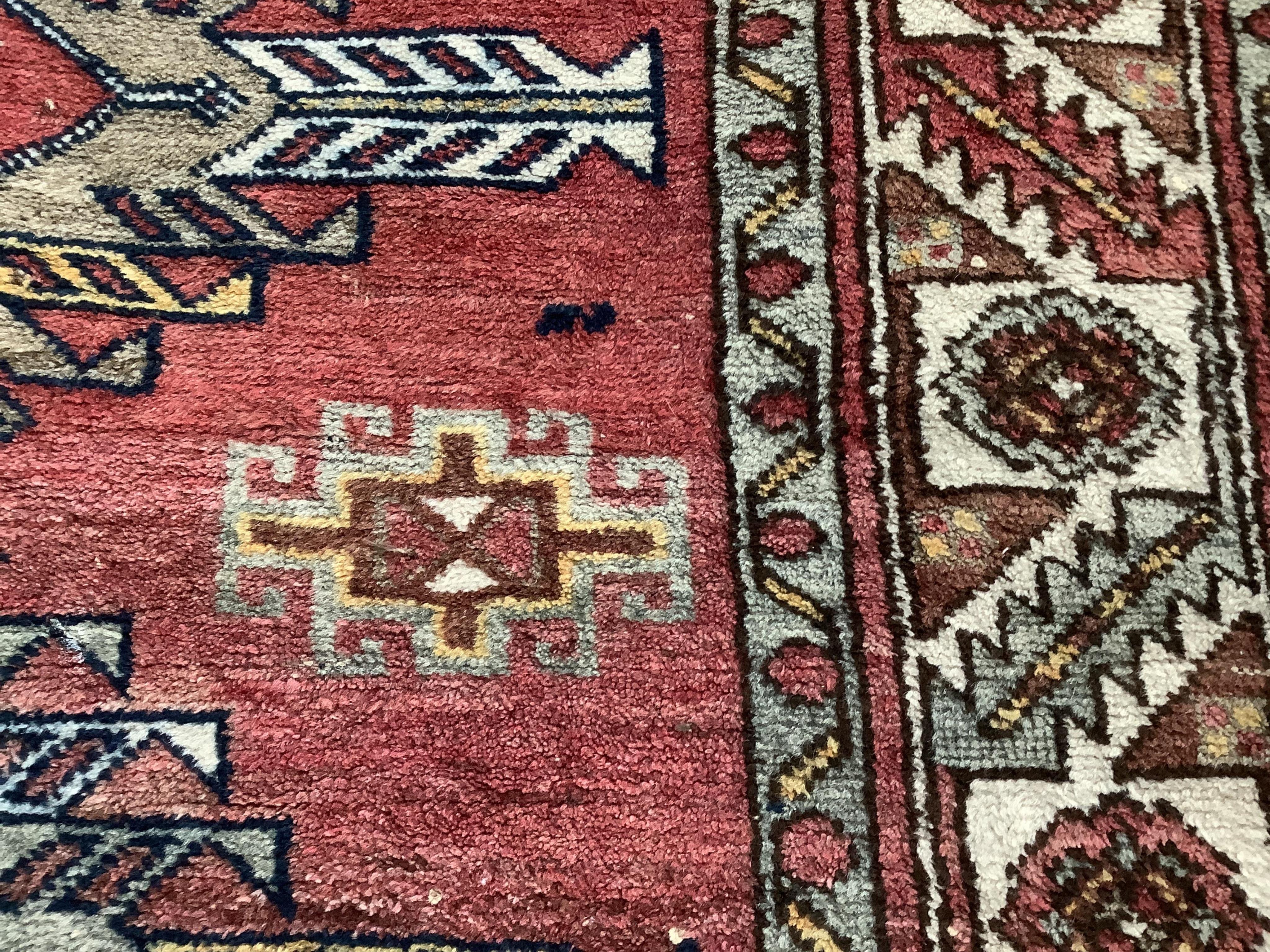 A Caucasian style red ground rug, 210 x 120cm. Condition - fair